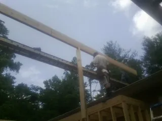 Carpenter setting a ridge beam over a new addition frame — Ice Dam Removal by Roofing Brothers in Hospers