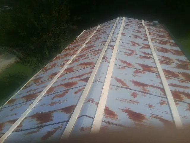 Rusted metal roof panels with new wood purlins before replacement — Storm Damage Roof Repair in Hospers by Roofing Brothers